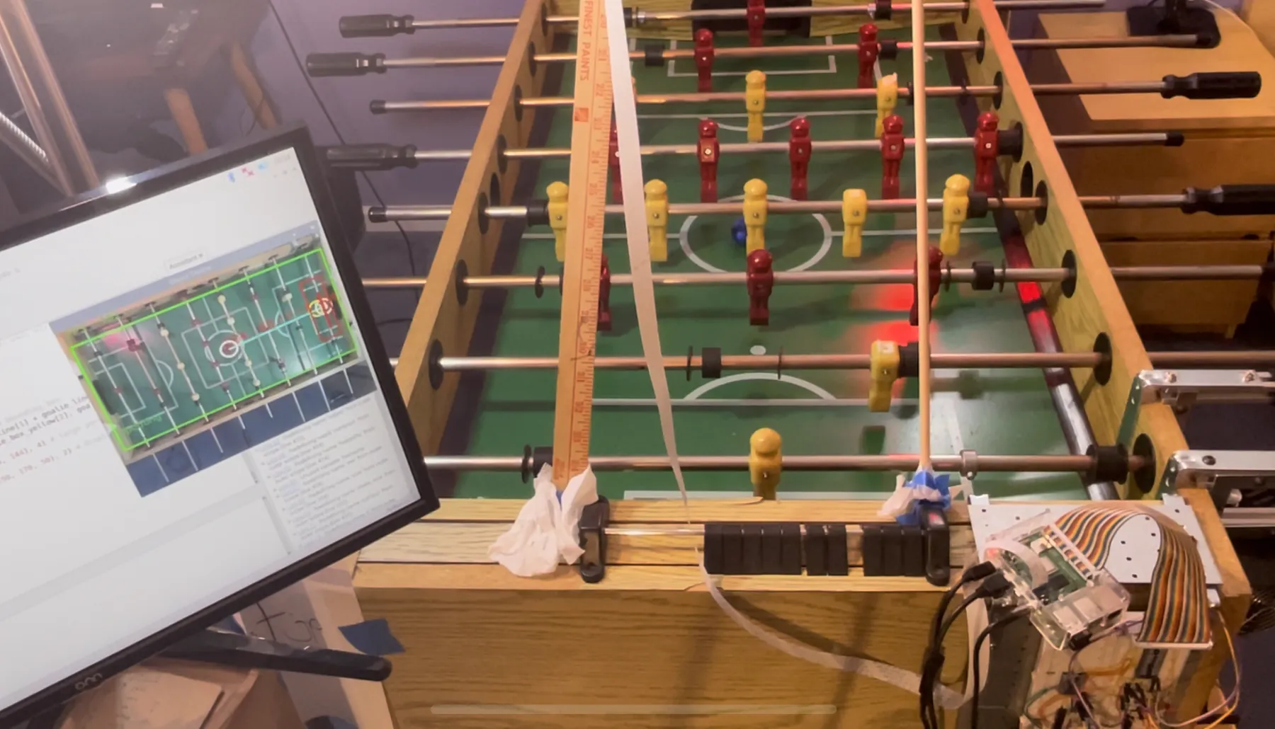The finished setup in use: the table with the camera rig overhead and the electronics on the right, and the tracker view running on the monitor at the left